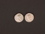 a close up of two silver coins on a black surface