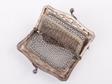 un sac à main ancien en argent muni d'une anse en filet, sur fond blanc
