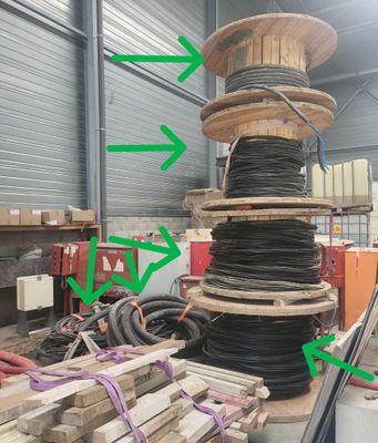 une grande pile de palettes en bois sur lesquelles sont dessinées des flèches vertes