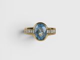 an oval blue sapphire and diamond ring with baguets in yellow gold