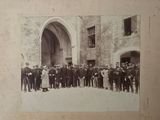 une vieille photo montrant un groupe d'hommes debout devant un bâtiment