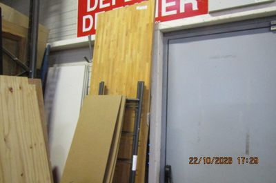 Plusieurs morceaux de bois sont empilés devant une porte
