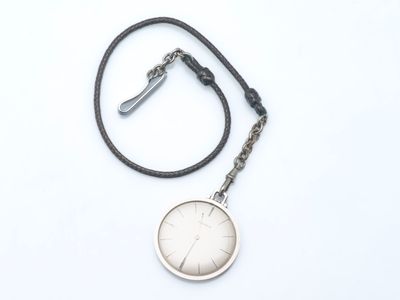 une montre argentée montée sur un bracelet en cuir noir, sur fond blanc