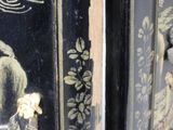 a close up of a black and gold decorated cabinet