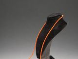 a necklace with an orange cord on a black stand