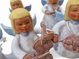 three figurines of angels holding musical instruments