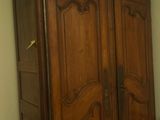 a wooden armoire in the corner of a room