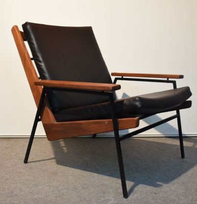 une image représentant une chaise avec une assise en cuir noir et une structure en bois
