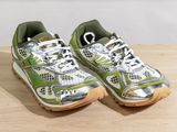 pair of green and white running shoes sitting on a wooden table