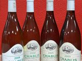 six bottles of wine are lined up on a wooden table