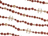a close up of a red beaded necklace on a white background