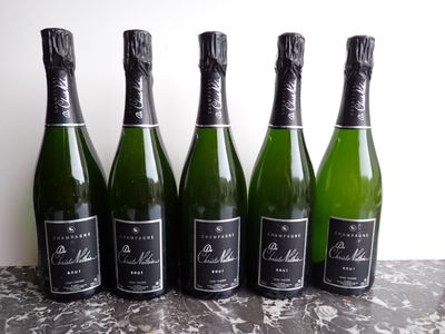 six bottles of champagne lined up on a table