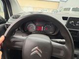 someone is holding a steering wheel while driving a small car
