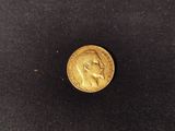 a gold coin with a profile of a man on it