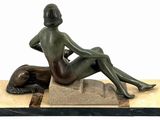 statue of a woman sitting on a rock with a dog