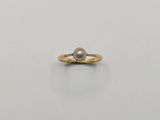 une bague en or avec une perle au centre