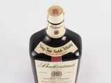 an image of a bottle of liquor sitting on top of a white surface