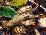 a close up of a decorative plate with shells and a lobster
