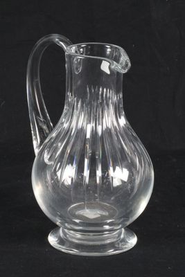 a clear glass pitcher sitting on a black surface