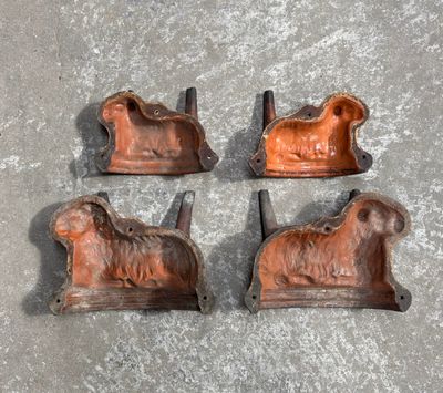 four antique cast iron animal bookends on a cement surface