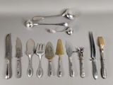 many different types of silverware on a white table