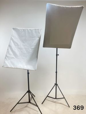 a picture of a photo studio with a white backdrop and a black tripod