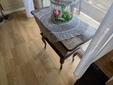 une cage à oiseaux ornée de fleurs, posée sur une table devant une fenêtre