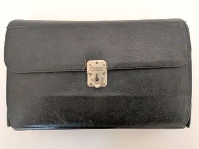 black leather briefcase sitting on top of a white surface