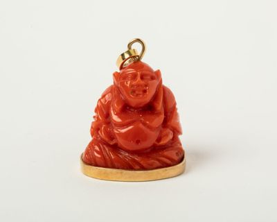 une image représentant une petite statuette de Bouddha rouge posée sur un socle plaqué or