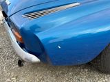 a close up of a blue car parked in a parking lot