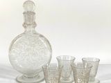 four glasses and a decanter sitting on a table