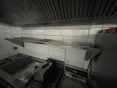 une photo d'une cuisine avec une cuisinière et une plaque de cuisson
