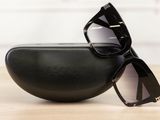 black sunglasses on a black case on a wooden table