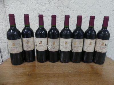six bouteilles de vin sont alignées sur une table en bois