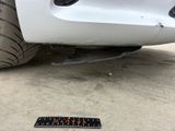 a sticker on the ground next to a white car