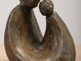 statue d'une mère tenant son enfant dans ses bras, posée sur une table