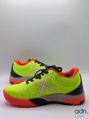 a pair of yellow and black tennis shoes on a white background
