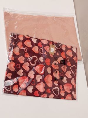 two bags with hearts printed on them on a table