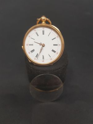 a small clock that is sitting on a black surface