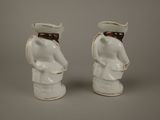 pair of white ceramic figurines of a sailor and a sailor woman
