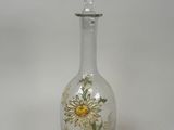 a glass bottle with a flower painted on it