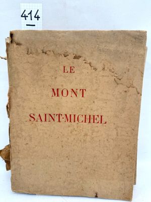 an old book sitting on top of a white table next to a white wall