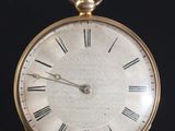une montre de poche ancienne avec des chiffres romains sur un cadran noir