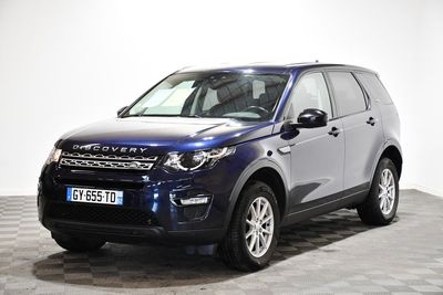 La Land Rover bleue est garée sur un sol en carrelage à damier.