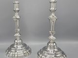 a pair of silver candlesticks on stands on a table