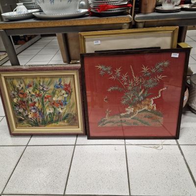 three framed pictures of flowers and birds on a table in a kitchen