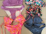 un tas de maillots de bain étalés sur un sol carrelé