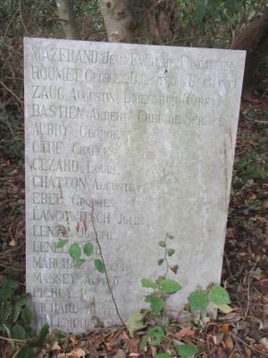 une pierre tombale au milieu des bois, avec un arbre en arrière-plan