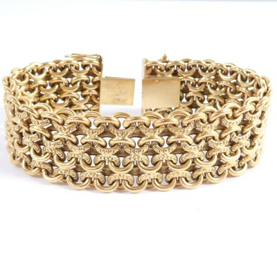 a close up of a gold bracelet on a white background