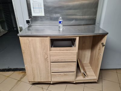 a stainless steel sink and a wooden cabinet in a kitchen